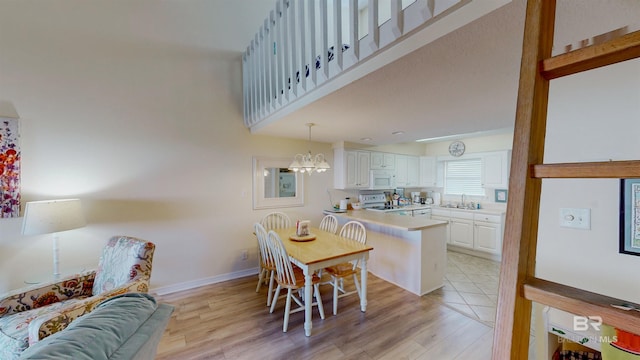 28835 Perdido Beach Blvd Unit 309, Orange Beach, AL 36561 - dining area featuring light wood finished floors, a chandelier, and baseboards