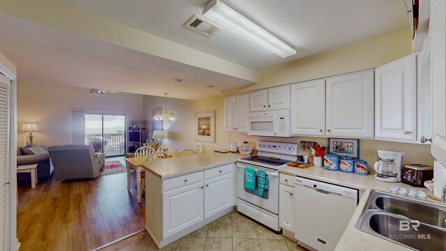 28835 Perdido Beach Blvd Unit 309, Orange Beach, AL 36561 - kitchen featuring white appliances, a peninsula, a sink, light countertops, and open floor plan