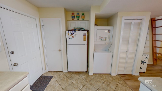 28835 Perdido Beach Blvd Unit 309, Orange Beach, AL 36561 - kitchen with freestanding refrigerator, stacked washer and clothes dryer, and light countertops