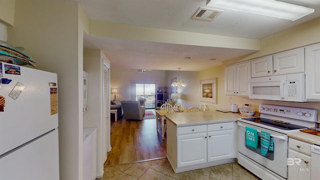 28835 Perdido Beach Blvd Unit 309, Orange Beach, AL 36561 - kitchen with white appliances, a peninsula, white cabinetry, and light countertops