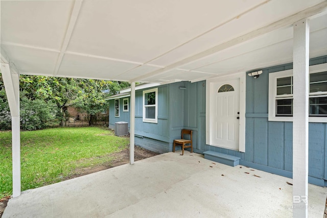 1716 Bryan Ave, Mobile, AL 36605 - doorway to property with a lawn, central AC, a patio area, an attached carport, and board and batten siding