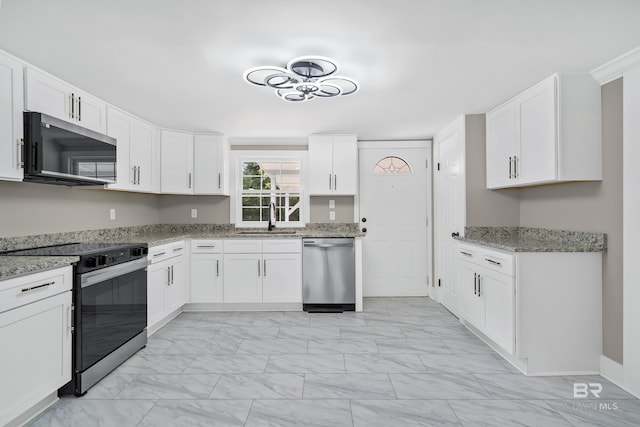 1716 Bryan Ave, Mobile, AL 36605 - kitchen featuring appliances with stainless steel finishes, light marble finish flooring, a sink, and white cabinets