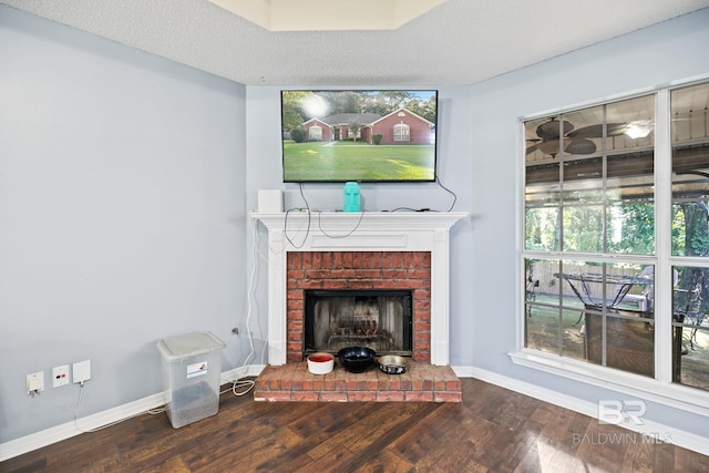 living room with hardwood / wood-style floors, a textured ceiling, and a fireplace