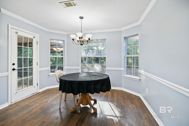 dining space with a textured ceiling, crown molding, dark hardwood / wood-style floors, and a notable chandelier