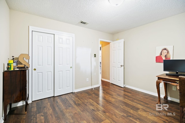 office area with dark hardwood / wood-style flooring and a textured ceiling