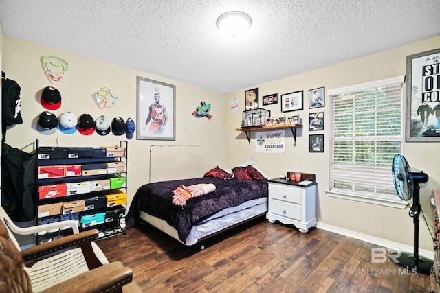 bedroom featuring a textured ceiling and dark hardwood / wood-style floors