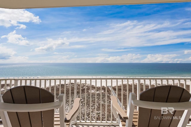 balcony featuring a water view and a beach view