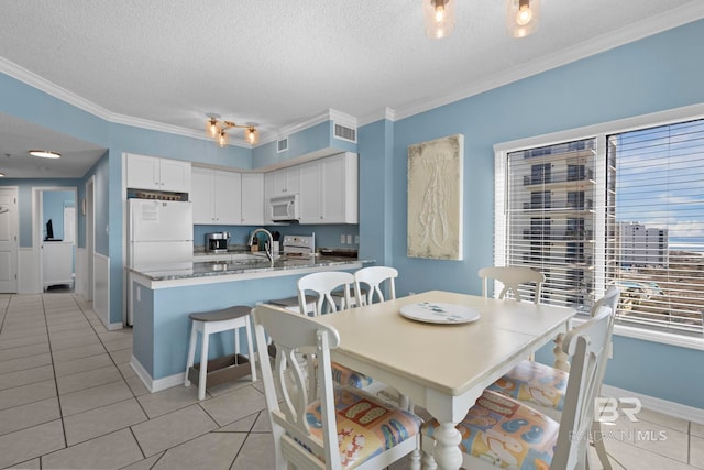 dining space with light tile patterned floors, a textured ceiling, visible vents, and crown molding