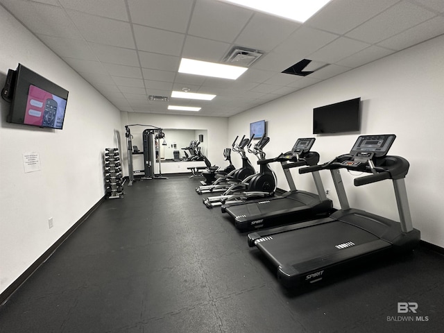 workout area featuring visible vents, a paneled ceiling, and baseboards