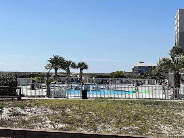 community pool featuring a yard and fence