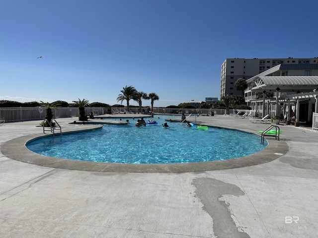 community pool featuring fence and a patio