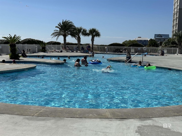 community pool featuring a patio area and fence