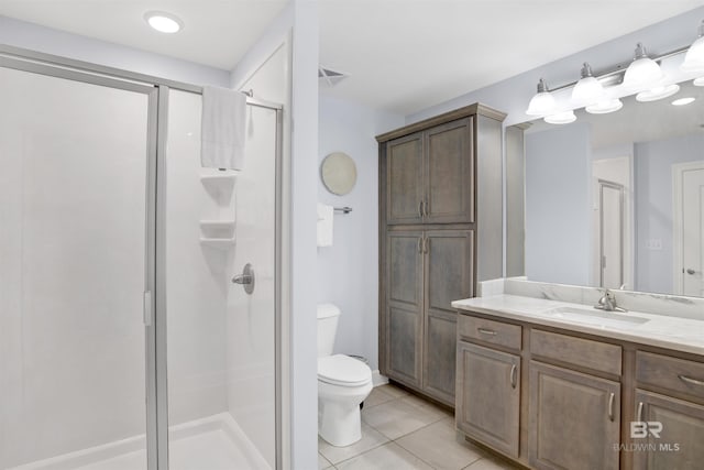 bathroom featuring a stall shower, tile patterned floors, toilet, and vanity