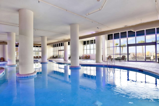 indoor community pool featuring a bar and a patio