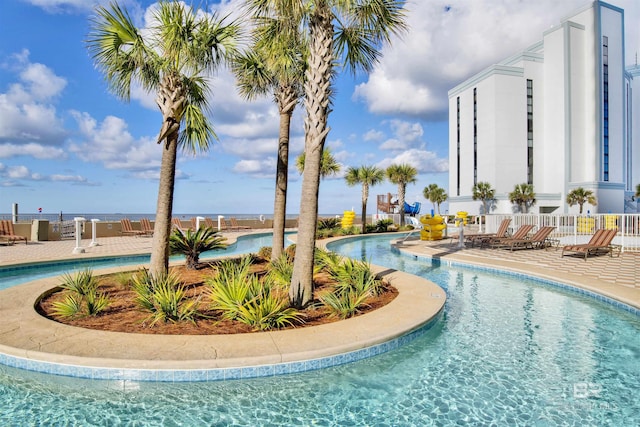 community pool featuring fence and a patio