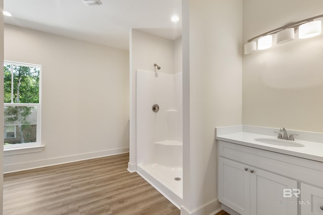 9264 Brighton Ave, Elberta, AL 36530 - bathroom with a shower, wood finished floors, vanity, and baseboards