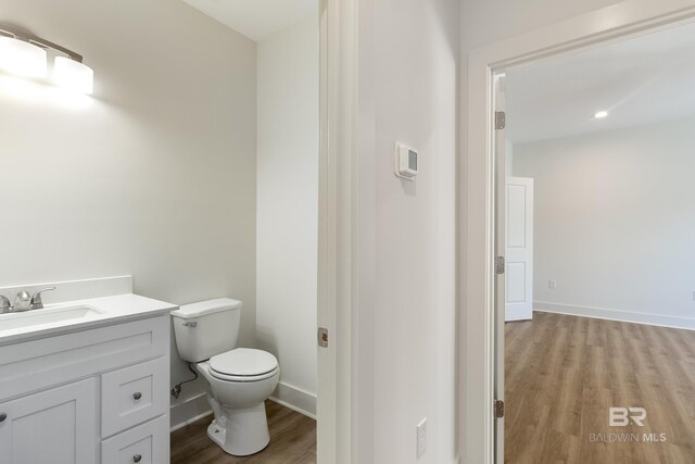 9264 Brighton Ave, Elberta, AL 36530 - bathroom featuring wood finished floors, toilet, vanity, and baseboards
