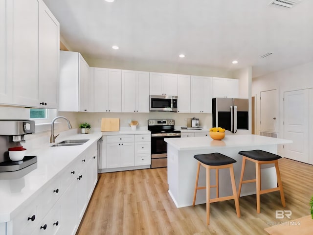 9264 Brighton Ave, Elberta, AL 36530 - kitchen with stainless steel appliances, a sink, light wood-style flooring, a kitchen bar, and a kitchen island