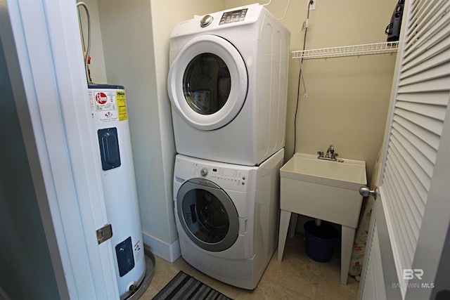 laundry room with water heater, light tile floors, and stacked washer and dryer