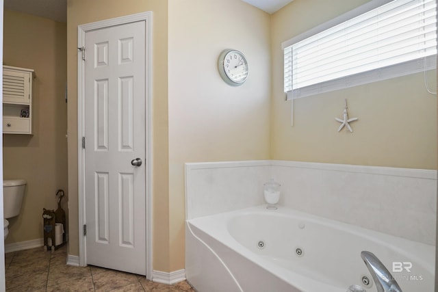1500 Thames Dr, Foley, AL 36535 - bathroom featuring toilet, baseboards, a tub with jets, and tile patterned flooring