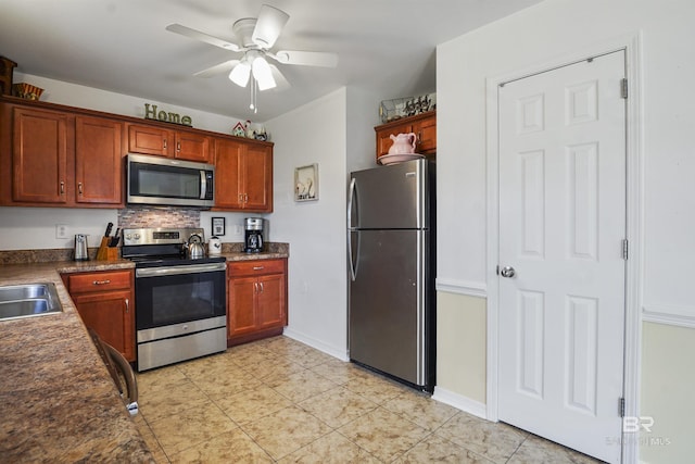 1500 Thames Dr, Foley, AL 36535 - kitchen with ceiling fan, appliances with stainless steel finishes, light tile patterned flooring, a sink, and dark countertops