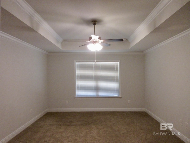 spare room featuring ceiling fan, a tray ceiling, and ornamental molding