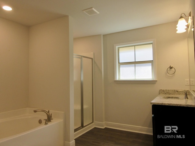 bathroom featuring hardwood / wood-style floors, vanity, and shower with separate bathtub