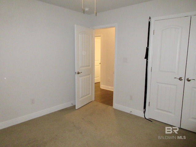 unfurnished bedroom with a closet and light carpet