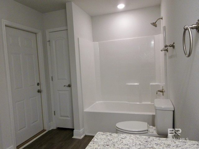 bathroom featuring hardwood / wood-style flooring, shower / bathing tub combination, and toilet