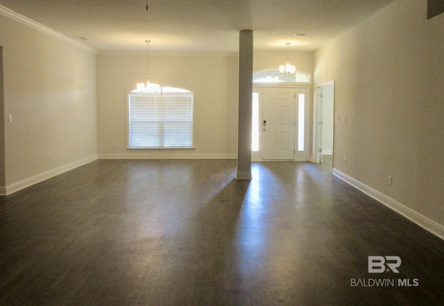 entrance foyer with a notable chandelier, dark hardwood / wood-style flooring, and ornamental molding