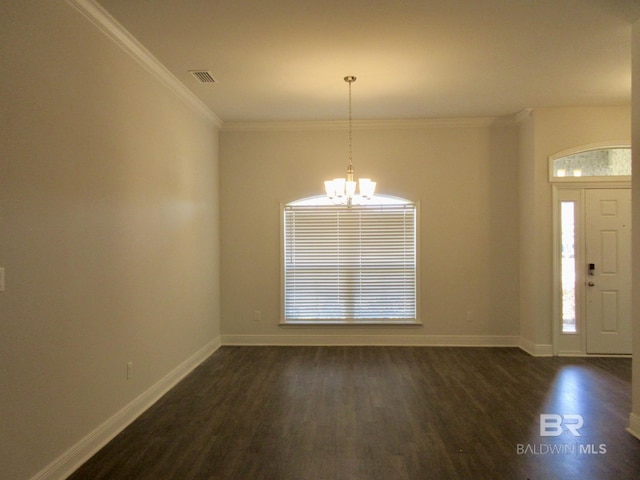 foyer entrance featuring dark hardwood / wood-style flooring, crown molding, and a chandelier