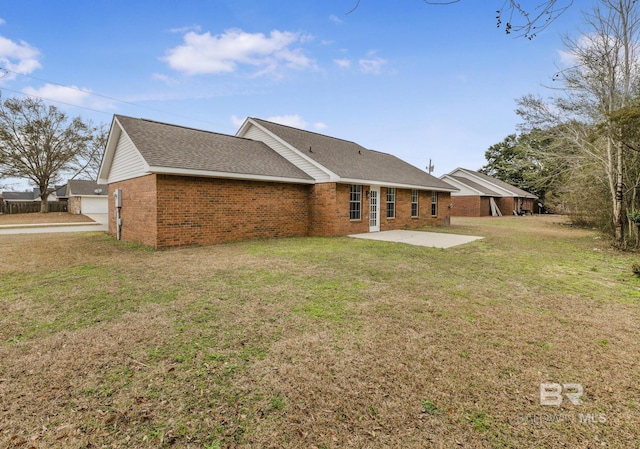 rear view of property featuring a lawn and a patio