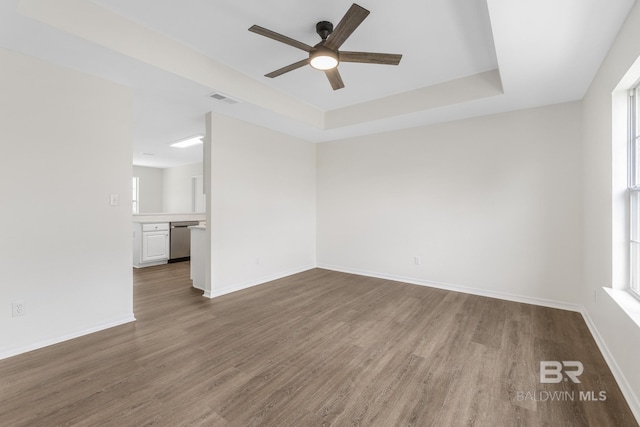 unfurnished room featuring wood-type flooring, a raised ceiling, and ceiling fan