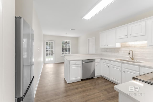 kitchen featuring white cabinetry, appliances with stainless steel finishes, sink, and kitchen peninsula