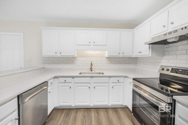 kitchen featuring white cabinetry, sink, light hardwood / wood-style floors, and appliances with stainless steel finishes