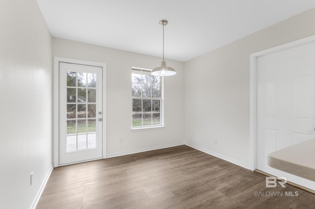 unfurnished dining area featuring dark hardwood / wood-style floors and a wealth of natural light