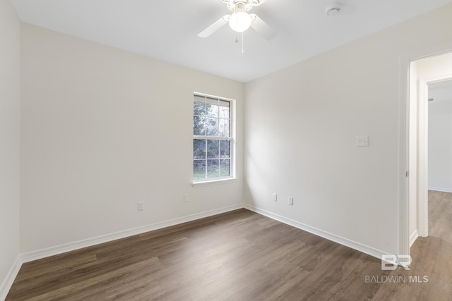 empty room with ceiling fan and dark hardwood / wood-style flooring