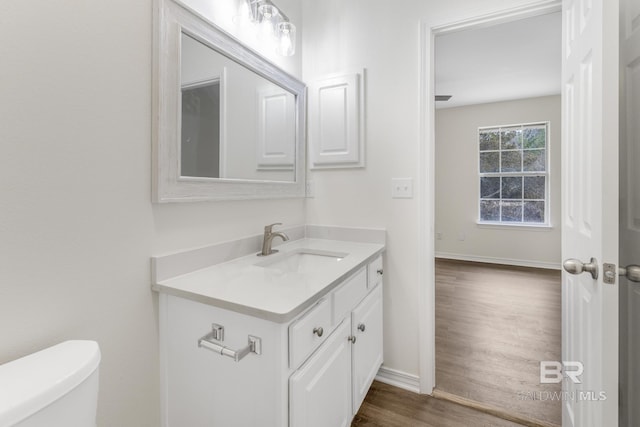 bathroom with vanity, toilet, and wood-type flooring