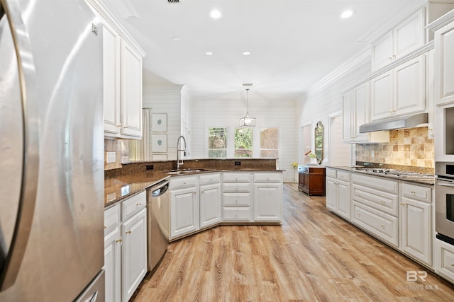 kitchen with sink, white cabinets, decorative light fixtures, and appliances with stainless steel finishes