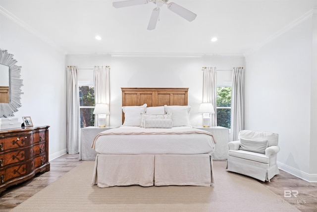 bedroom with ceiling fan, light wood-type flooring, ornamental molding, and multiple windows