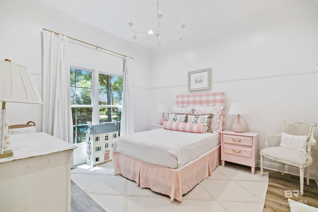 bedroom featuring light hardwood / wood-style floors, crown molding, and a notable chandelier