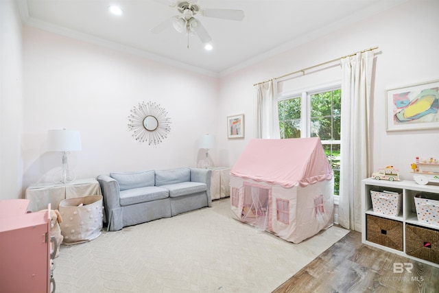 rec room featuring wood-type flooring, ornamental molding, and ceiling fan