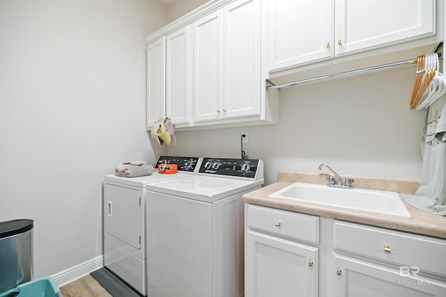 laundry area with washer and dryer, hardwood / wood-style flooring, cabinets, and sink