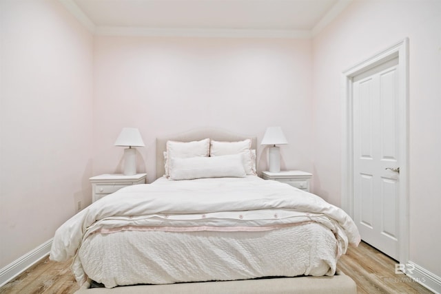 bedroom featuring crown molding and light hardwood / wood-style flooring