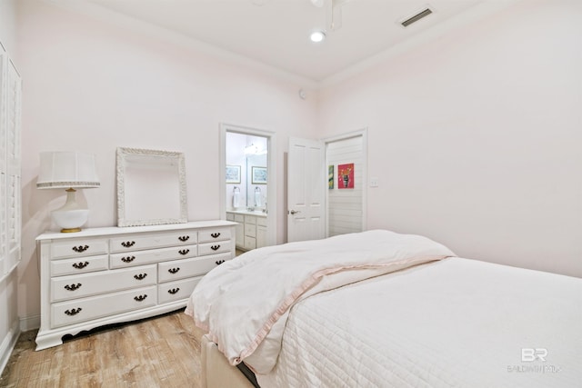 bedroom with ensuite bath, light hardwood / wood-style floors, and ornamental molding