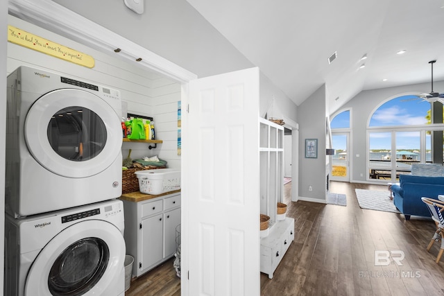 clothes washing area featuring stacked washing maching and dryer, dark hardwood / wood-style flooring, cabinets, and ceiling fan