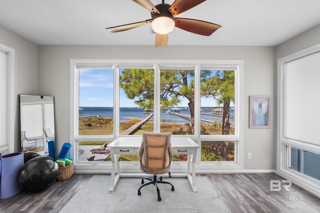 office area featuring a water view, wood-type flooring, and ceiling fan