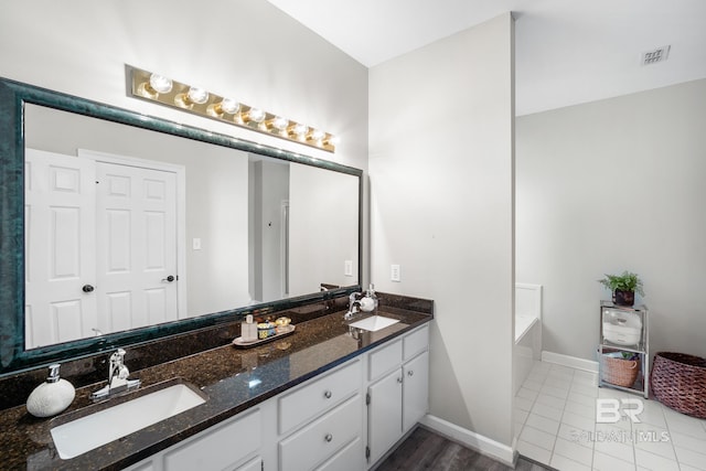 bathroom featuring a bath, vanity, and tile patterned floors