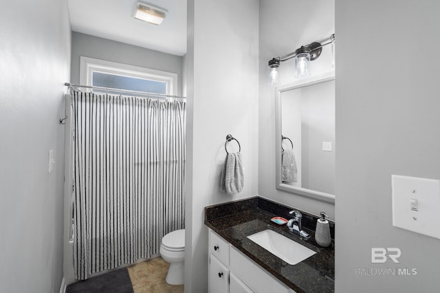 bathroom featuring toilet, vanity, and walk in shower