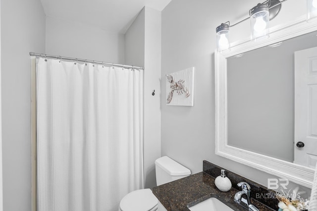 bathroom with toilet, vanity, and curtained shower